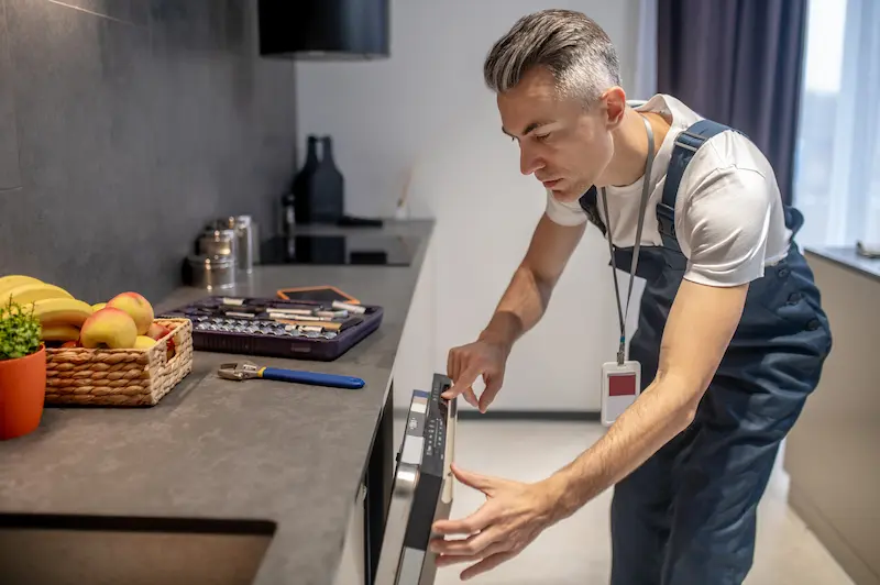 Technician Fixing a Dishwasher - Appliances Repair Solutions